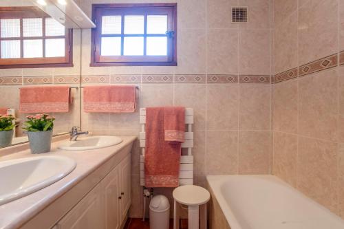 uma casa de banho com 2 lavatórios e uma banheira. em Micaes - maison avec piscine privée em Roquebrune-sur-Argens
