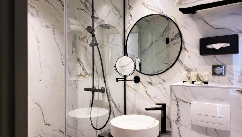 a bathroom with a shower and a toilet and a mirror at Star Champs-Elysées in Paris