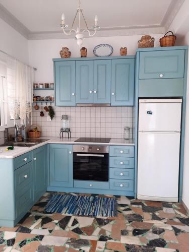a kitchen with blue cabinets and a white appliance at "Gorgones" Mermaids Place in Kalymnos