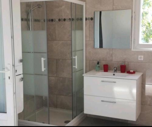 La salle de bains est pourvue d'une douche, d'un lavabo et d'un miroir. dans l'établissement Mimosas - villa, à Fréjus