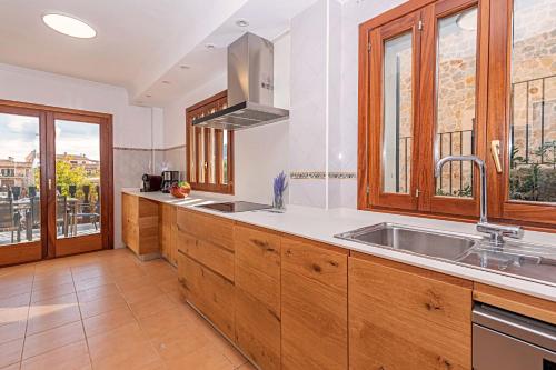 eine Küche mit Holzschränken und einem Waschbecken in der Unterkunft Villa PARADISE in Palma de Mallorca