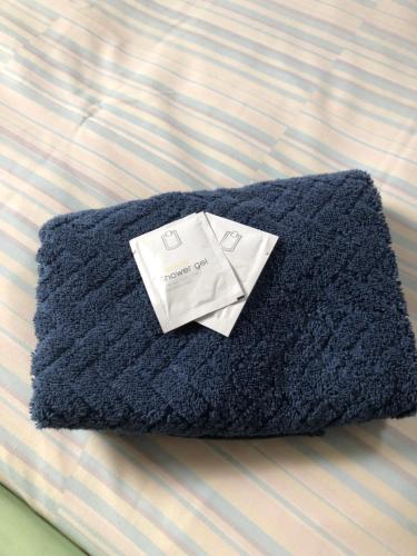 a black towel sitting on top of a bed at Ancien Relais de Poste The Old Post Office in Saint-Martial-dʼAlbarède