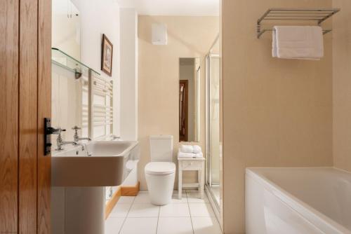 Ένα μπάνιο στο Threshing Barn at East Trenean Farm -Stunning Cornish Cottage sleeping 6 with hot tub, private garden, rural views and EV facilities