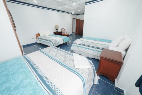Habitación de hotel con 2 camas y espejo en Casa Marina Galapagos, en Puerto Ayora