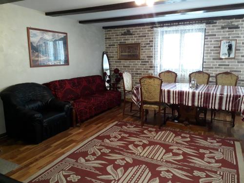 - un salon avec un canapé rouge et une table dans l'établissement Pensiunea Casa Fierarul din Bucovina, à Vatra Moldoviţei