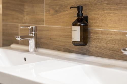 a bottle of soap sitting on a wall next to a sink at Casa Tegernsee - zentral, modern, Nespresso, 3 Min zum See in Gmund am Tegernsee