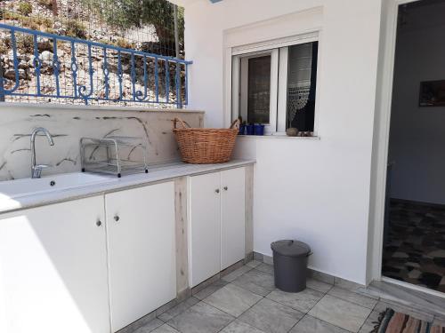a kitchen with white cabinets and a sink and a window at "Gorgones" Mermaids Place in Kalymnos
