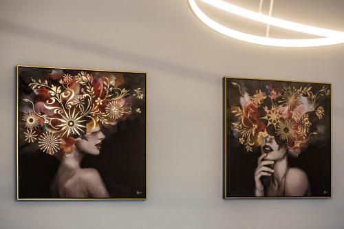 two framed pictures of women on a wall at Suites Mana - La Perle des Isles , Superbe maison Art déco avec balnéothérapie in Rethel