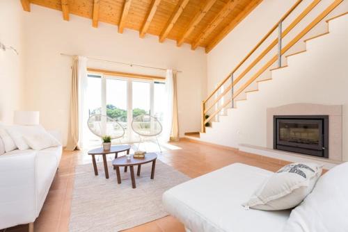 un soggiorno con un divano bianco e un camino di Villas T3 com Jardim Vila Sagres a Sagres