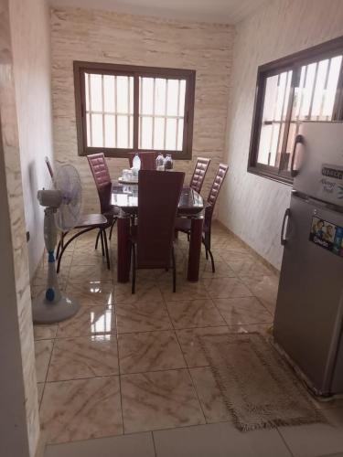 a dining room with a table and chairs and a refrigerator at Reserva africa Cité Mokpokpo in Lomé