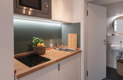 uma cozinha com um lavatório e um micro-ondas em St. Salvator Apartments em Fulda