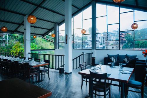 a restaurant with tables and chairs and windows at 49 Ella in Ella
