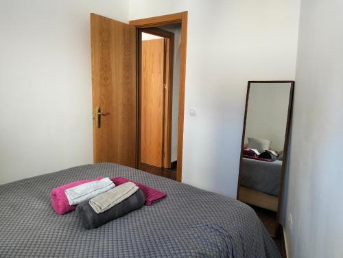 een slaapkamer met een bed met 2 kussens en een spiegel bij La corrala de Malasaña in Madrid