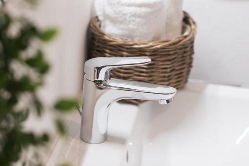 a bathroom sink with a faucet and a basket of towels at St. Salvator Apartments in Fulda