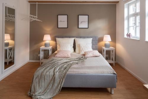a bedroom with a bed with two lamps on two tables at St. Salvator Apartments in Fulda