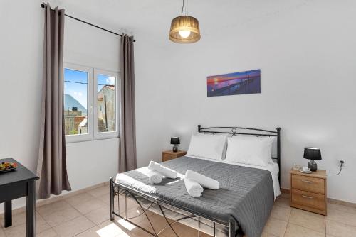 1 dormitorio con cama, escritorio y ventana en Bella-Maria at Aptera with mountain and sea view !! en La Canea