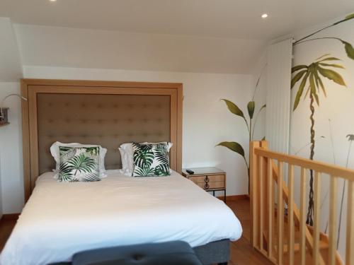 a bedroom with a large white bed with two pillows at Hotel et Spa Le Lion d'Or in Pont-lʼÉvêque