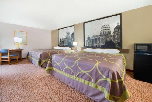 um quarto de hotel com duas camas e uma secretária em Super 8 by Wyndham Pella em Pella