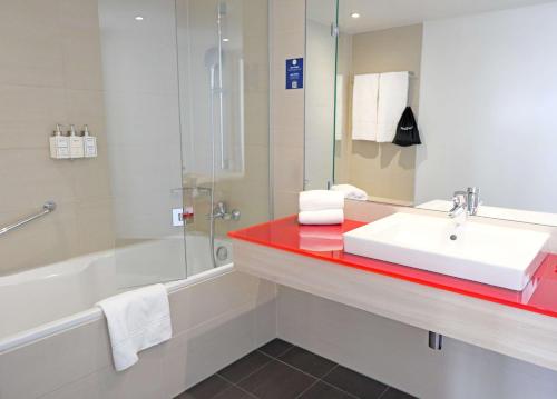 a bathroom with a sink and a shower and a tub at Park Inn by Radisson Linz in Linz