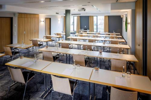 a classroom with rows of tables and chairs at Lanzcarré Hotel Mannheim, a member of Radisson Individuals in Mannheim