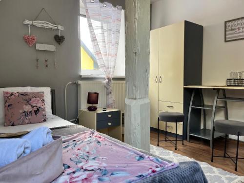 a bedroom with a bed and a desk and a window at Penzion Pomodoro in Vrbno pod Pradědem