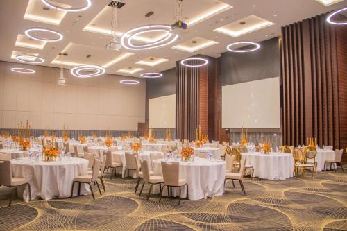 a large banquet hall with white tables and chairs at Radisson Blu Hotel, Juba in Juba