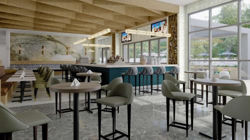 a restaurant with tables and chairs and a bar at Hyatt House Orlando Airport in Orlando