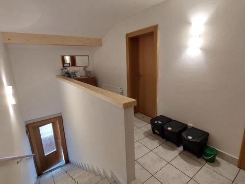 a room with a staircase and two black luggage at Apartment Unterpirchhof by Interhome in Thumersbach
