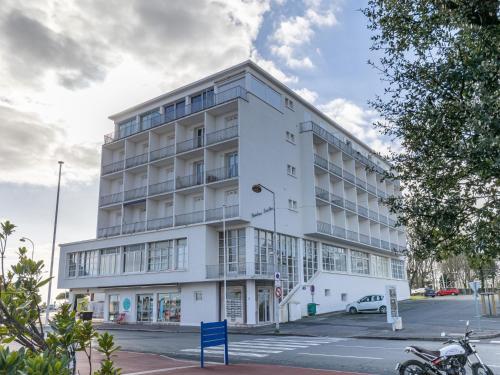 a white building on a street with a car parked in front at Apartment Foncillon by Interhome in Royan