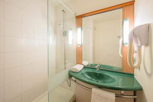 een badkamer met een groene wastafel en een douche bij ibis Saint Rambert d'Albon in Saint-Rambert-dʼAlbon