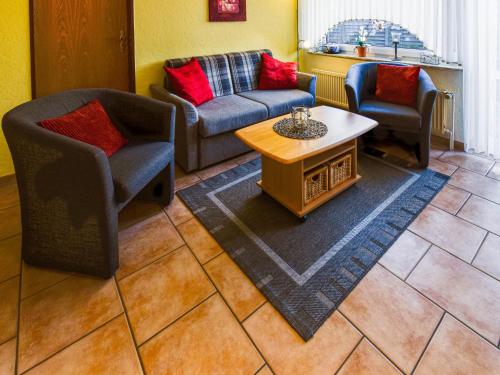 ein Wohnzimmer mit zwei Stühlen und einer Couch und einem Tisch in der Unterkunft Apartment Tjalkstrasse-3 by Interhome in Norddeich