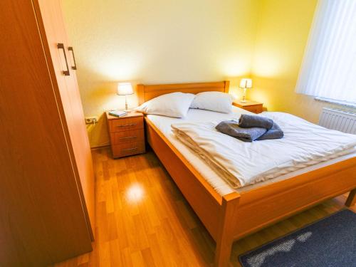 ein Schlafzimmer mit einem Bett mit weißer Bettwäsche und zwei Lampen in der Unterkunft Apartment Tjalkstrasse-3 by Interhome in Norddeich
