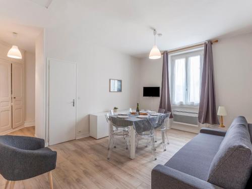 een woonkamer met een tafel en een bank bij Apartment Le Petit Robinson-2 by Interhome in La Richardais