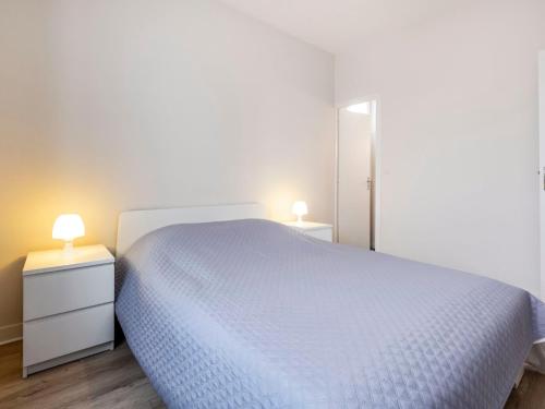 1 dormitorio con 1 cama blanca y 2 mesitas de noche en Apartment Le Petit Robinson-2 by Interhome en La Richardais