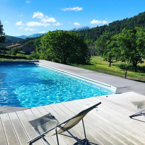 - une piscine avec une terrasse et deux chaises à côté dans l'établissement HAMEAU DE LA SAVOUILLANE, à Buis-les-Baronnies