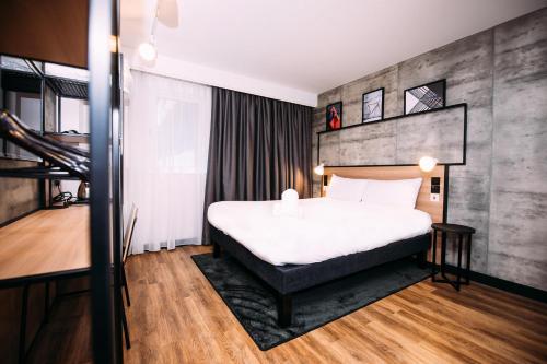 a hotel room with a bed and a staircase at ibis Belfast City Centre in Belfast