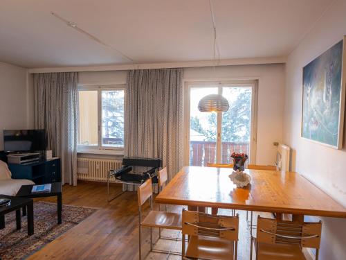 ein Wohnzimmer mit einem Holztisch und einem Esszimmer in der Unterkunft Apartment Chesa Romantica 17 by Interhome in St. Moritz