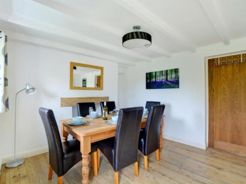 a dining room with a wooden table and black chairs at Holiday Home St Issay by Interhome in Saint Issey