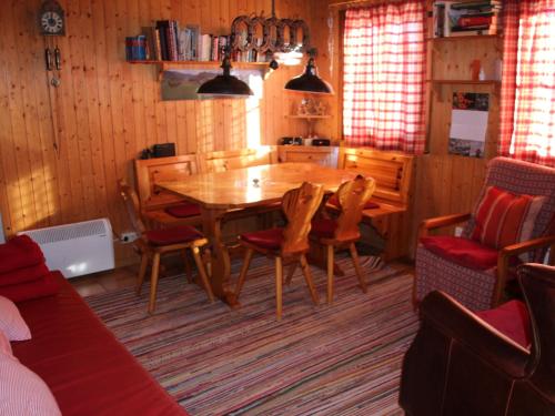 a dining room with a wooden table and chairs at Chalet Henri by Interhome in Moleson