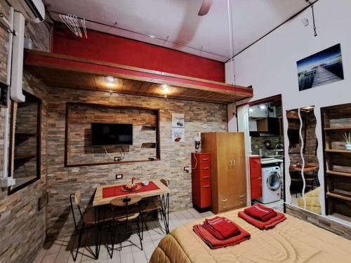 um quarto com uma cozinha e uma mesa com cadeiras em il rifugio em Palermo