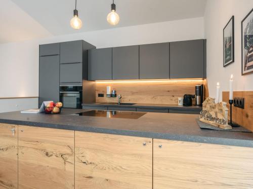 a kitchen with black cabinets and a wooden counter top at Chalet Mountain Lodge - Klippitztörl by Interhome in Klippitztorl