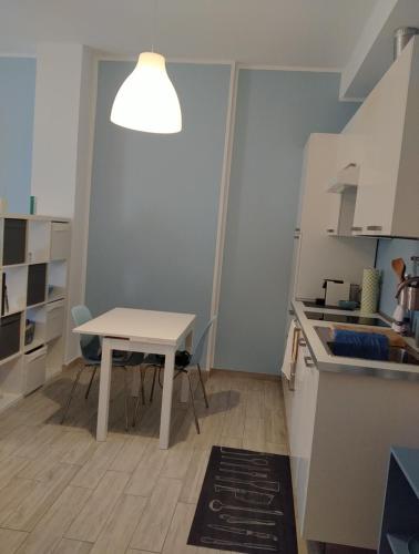 una cocina con una mesa y una mesa blanca y una mesa y un taburete en Dimora Anna en Termoli