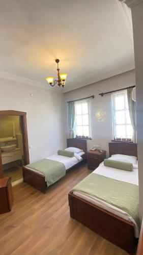 two beds in a room with two windows at Kaleici Hotel in Antalya