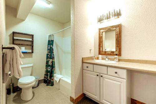 een badkamer met een wastafel, een toilet en een spiegel bij Summer Escape at the Loose Moose #3 in Grand Lake