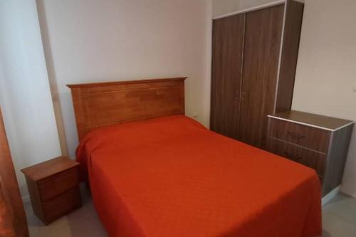 een slaapkamer met een oranje bed en een kast bij 2 Bedroom Apartment close to all amenities in Highlands
