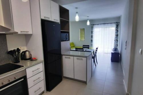 een keuken met witte kasten en zwarte apparaten bij 2 Bedroom Apartment close to all amenities in Highlands