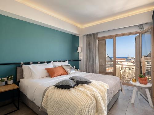 1 dormitorio con 1 cama grande y pared azul en Elia Bettolo Hotel en La Canea
