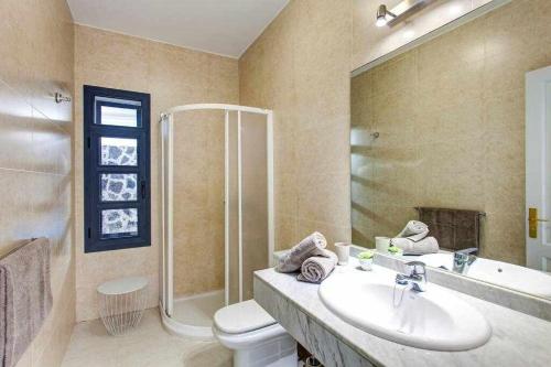 La salle de bains est pourvue d'un lavabo, d'une douche et de toilettes. dans l'établissement Homu Bianca Fantástica villa con piscina privada, à Playa Blanca