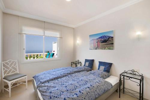 ein Schlafzimmer mit einem Bett, einem Fenster und einem Stuhl in der Unterkunft casa Daniela in Santa Úrsula