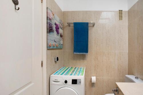 a bathroom with a washing machine and a blue towel at casa Daniela in Santa Úrsula